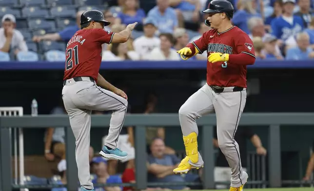 Arizona Diamondbacks' Joc Pederson (3) celebrates with third base coach Tony Perezchica (21) after hitting a home run during the fourth inning of a baseball game against the Kansas City Royals in Kansas City, Mo., Wednesday, July 24, 2024. (AP Photo/Colin E. Braley)