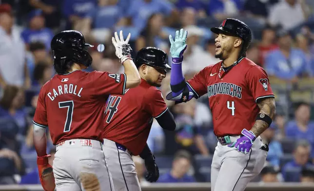 Arizona Diamondbacks' Ketel Marte (4) celebrates hitting a three-run home run with Corbin Carroll (7) and Gabriel Moreno (14) during the ninth inning of a baseball game against the Kansas City Royals in Kansas City, Mo., Wednesday, July 24, 2024. (AP Photo/Colin E. Braley)