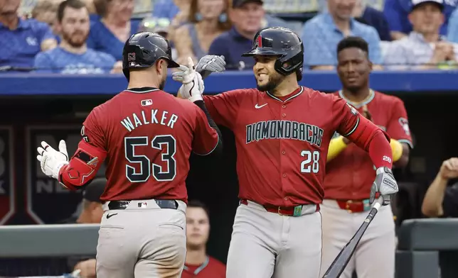 Arizona Diamondbacks' Christian Walker (53) celebrates hitting a home run with Eugenio Suarez (28) during the fourth inning of a baseball game against the Kansas City Royals in Kansas City, Mo., Wednesday, July 24, 2024. (AP Photo/Colin E. Braley)