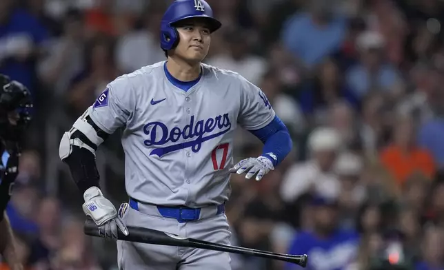 Los Angeles Dodgers designated hitter Shohei Ohtani heads to first base after drawing a walk during the sixth inning of a baseball game against the Houston Astros, Friday, July 26, 2024, in Houston. (AP Photo/Kevin M. Cox)