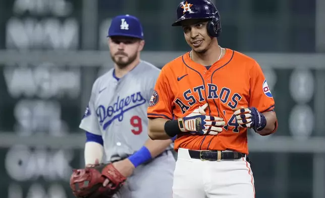 Houston Astros pinch hitter Mauricio Dubón, right, celebrates after hitting an RBI double as Los Angeles Dodgers second baseman Gavin Lux, left, looks on during the eighth inning of a baseball game Friday, July 26, 2024, in Houston. (AP Photo/Kevin M. Cox)