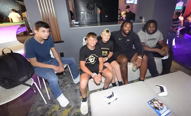 From left to right, Jayden Valdez, of Las Vegas, accompanies Abram Wilkerson and Braylee Bryant, both of Thornton, Colo., in joining Colorado center Yakiri Walker and offensive tackle Kareem Harden to play the EA Sports College Football 25 video game during a release party Friday, July 19, 2024, at the Memorial Union on the campus of the University of Colorado in Boulder, Colo. (AP Photo/David Zalubowski)