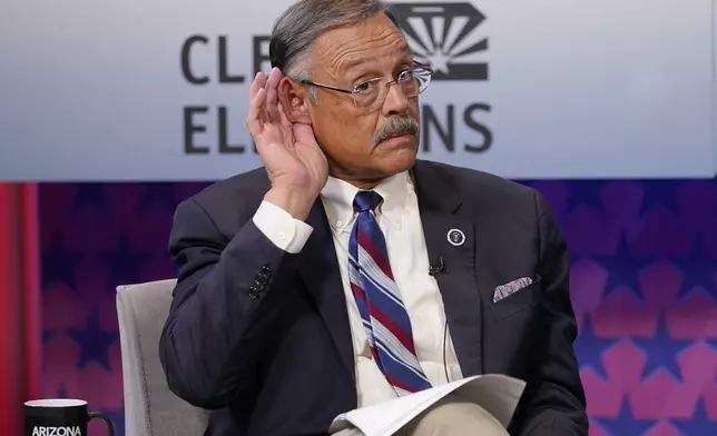 FILE - Arizona Secretary of State Republican candidate Mark Finchem listens to instructions prior to debating Democratic challenger Adrian Fontes, on Sept. 22, 2022, in Phoenix. (AP Photo/Matt York, File)