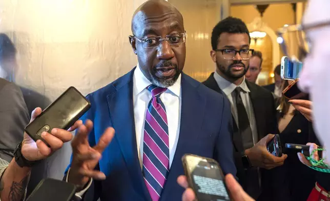 FILE - Sen. Raphael Warnock, D-Ga., speaks with reporters, Sept. 28, 2023, in Washington. Senior Democratic figures rallied publically around President Joe Biden on Sunday, June 30, 2024, amid private angst within the party about Thursday's debate performance. Warnock said during NBC's "Meet The Press," there had been "more than a few Sundays, when I wish I had preached a better sermon, but after the sermon was over it was my job to embody the message, to show up for the people that I serve. And that's what Joe Biden has been doing his entire life." (AP Photo/Alex Brandon, File)