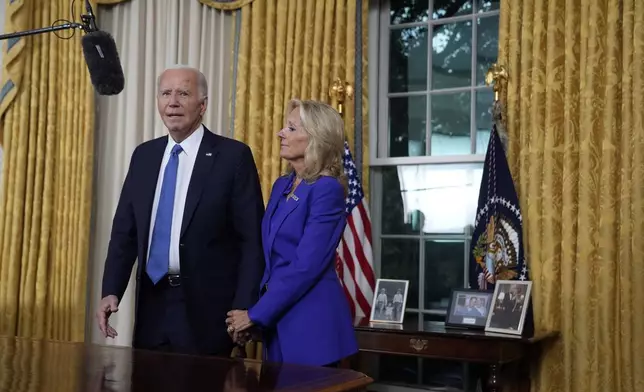 President Joe Biden stands next to first lady Jill Biden as he thanks the camera crew after addressing the nation from the Oval Office of the White House in Washington, Wednesday, July 24, 2024, about his decision to drop his Democratic presidential reelection bid. (AP Photo/Evan Vucci, Pool)