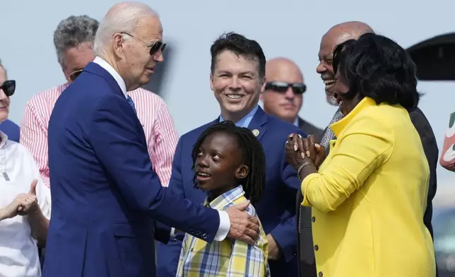 President Joe Biden, left, is greeted by Philadelphia Mayor Cherelle Parker, right, and her son Langston Mullins, center, as Rep. Brendan Boyle, D-Pa., looks on in background as Biden arrives at Philadelphia International Airport to participate in a campaign event in Philadelphia, Sunday, July 7, 2024. (AP Photo/Manuel Balce Ceneta)