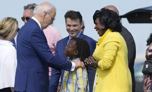 President Joe Biden, left, is greeted by Philadelphia Mayor Cherelle Parker, right, and her son Langston Mullins, center, as Rep. Brendan Boyle, D-Pa., looks on in background as Biden arrives at Philadelphia International Airport to participate in a campaign event in Philadelphia, Sunday, July 7, 2024. (AP Photo/Manuel Balce Ceneta)