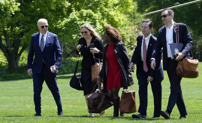 FILE - President Joe Biden, from left, walks with White House deputy chief of staff Annie Tomasini, White House press secretary Karine Jean-Pierre, White House deputy chief of staff Bruce Reed and White House communications director Ben LaBolt, as they cross the South Lawn of the White House in Washington, April 26, 2024, after returning from a trip to New York. (AP Photo/Susan Walsh, File)