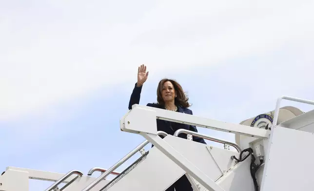 Vice President Kamala Harris waves while boarding Air Force Two as she departs on campaign travel to Milwaukee, Wisc., Tuesday, July 23, 2024 at Andrews Air Force Base, Md. (Kevin Mohatt/Pool via AP)