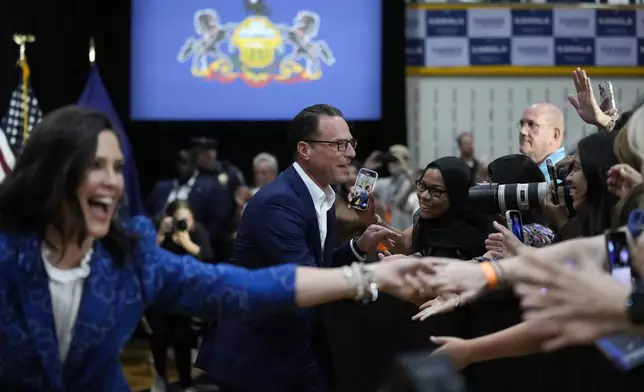 Michigan Gov. Gretchen Whitmer, left, and Pennsylvania Gov. Josh Shapiro, center, arrive at a campaign event for Democratic presidential candidate Vice President Kamala Harris in Ambler, Pa., Monday, July 29, 2024. (AP Photo/Matt Rourke)