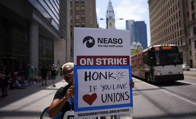 A demonstrator pickets in support of the National Education Association Staff Organization outside the Pennsylvania Convention Center, Friday, July 5, 2024, in Philadelphia. (AP Photo/Matt Slocum)