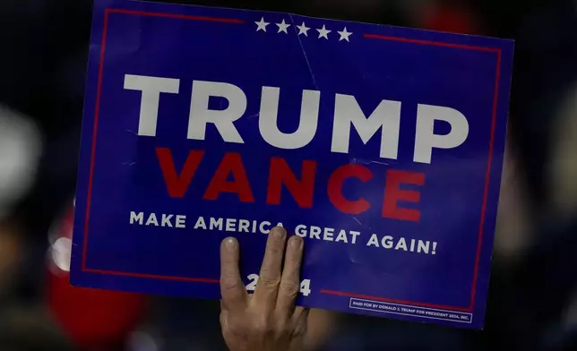 A suppoerter holds a sign during the Republican National Convention Tuesday, July 16, 2024, in Milwaukee. (AP Photo/Charles Rex Arbogast)