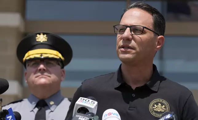 Josh Shapiro, right, governor of Pennsylvania, speaks during a news conference, in Butler, Pa., Sunday, July 14, 2024, concerning the apparent assassination attempt of former President Donald Trump. (AP Photo/Sue Ogrocki)