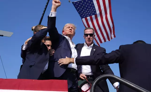 Republican presidential candidate former President Donald Trump gestures as he is surrounded by U.S. Secret Service agents as he leaves the stage at a campaign rally, Saturday, July 13, 2024, in Butler, Pa. (AP Photo/Evan Vucci)