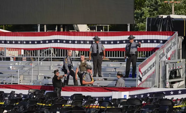 Law enforcement officers gather at campaign rally site for Republican presidential candidate former President Donald Trump is empty Saturday, July 13, 2024, in Butler, Pa. Trump's campaign said in a statement that the former president was "fine" after a shooting at his rally in Butler (AP Photo/Evan Vucci)