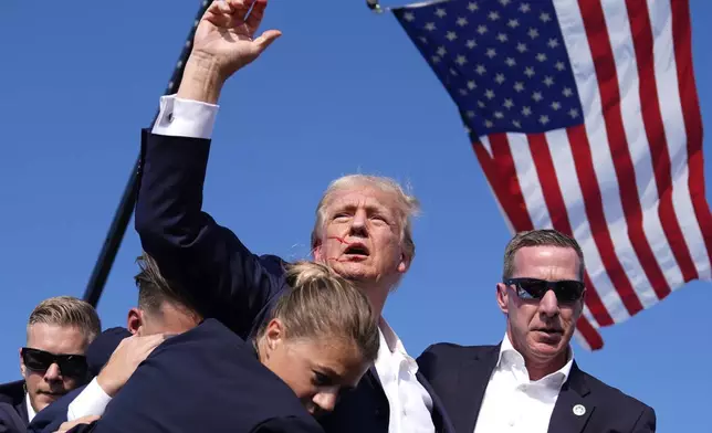 Republican presidential candidate former President Donald Trump is surrounded by U.S. Secret Service agents at a campaign rally, Saturday, July 13, 2024, in Butler, Pa. (AP Photo/Evan Vucci)