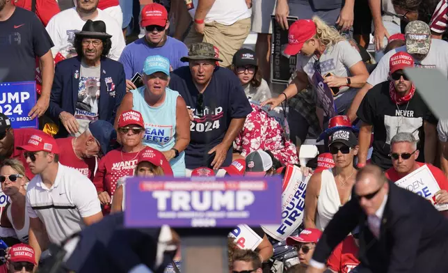 The crowd reacts as Republican presidential candidate former President Donald Trump is surrounded by U.S. Secret Service agents at a campaign event in Butler, Pa., on Saturday, July 13, 2024. (AP Photo/Gene J. Puskar)