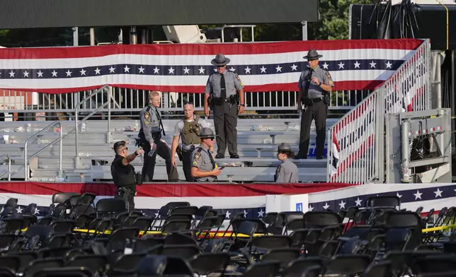 Law enforcement officers gather at campaign rally site for Republican presidential candidate former President Donald Trump is empty Saturday, July 13, 2024, in Butler, Pa. Trump's campaign said in a statement that the former president was "fine" after a shooting at his rally in Butler (AP Photo/Evan Vucci)