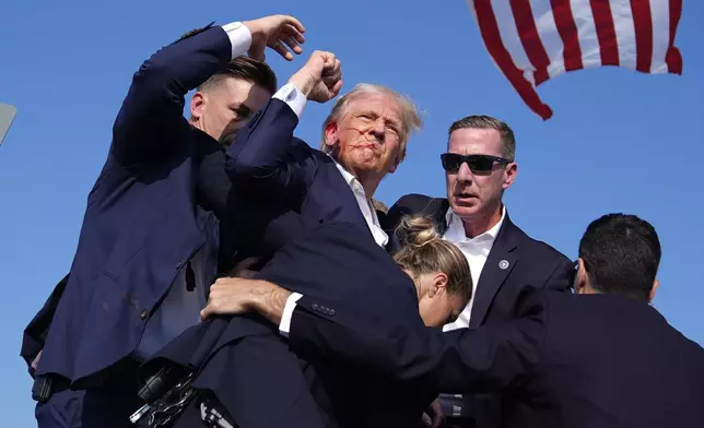 FILE - Republican presidential candidate former President Donald Trump is surround by U.S. Secret Service agents at a campaign rally, Saturday, July 13, 2024, in Butler, Pa. (AP Photo/Evan Vucci, File)