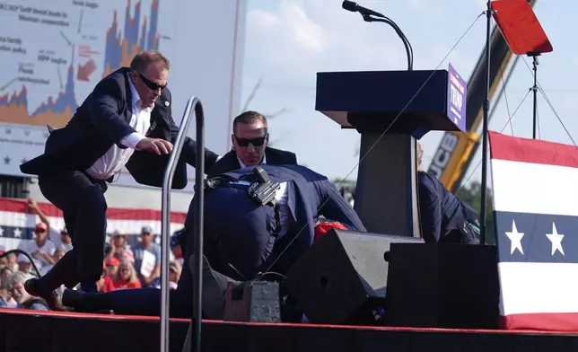 FILE - U.S. Secret Service agents converge to cover Republican presidential candidate former President Donald Trump at a campaign rally, Saturday, July 13, 2024, in Butler, Pa. (AP Photo/Evan Vucci, File)