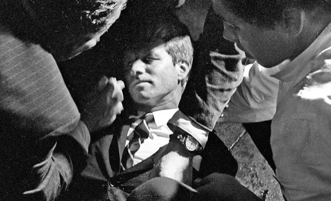 FILE - In this June 5, 1968 file photo, Hotel busboy Juan Romero, right, comes to the aid of Senator Robert F. Kennedy, as he lies on the floor of the Ambassador hotel in Los Angeles moments after he was shot. Romero was a teenage busboy in June 1968 when Kennedy walked through the Ambassador Hotel kitchen after his victory in the California presidential primary and an assassin shot him in the head. He held the mortally wounded Kennedy as he lay on the ground, struggling to keep the senator's bleeding head from hitting the floor. (Richard Drew/Pasadena Star News via AP, File)