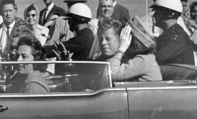 FILE - President John F. Kennedy waves from his car in a motorcade approximately one minute before he was shot, Nov. 22, 1963, in Dallas. Riding with President Kennedy are first lady Jacqueline Kennedy, right, Nellie Connally, second from left, and her husband, Texas Gov. John Connally, far left. (AP Photo/Jim Altgens, File)