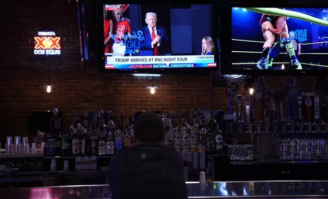 A man watches from the 11th Frame Bar and Grille in Butler, Pa., as Republican presidential candidate former President Donald Trump arrives on stage at the Republican National Convention, Thursday, July 18, 2024. (AP Photo/Matt Slocum)