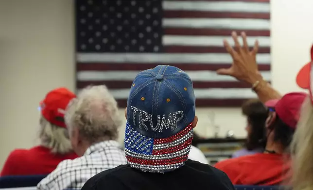 A supporter of Republican presidential candidate former President Donald Trump wears a bedazzled Trump hat as supporters watch his speech at the Republican National Convention in Milwaukee from the Arizona GOP headquarters Thursday, July 18, 2024, in Phoenix. (AP Photo/Ross D. Franklin)