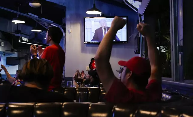 Supporters watch Republican presidential candidate former President Donald Trump speak at the Republican National Convention on a television Thursday, July 18, 2024, in Seal Beach, Calif. (AP Photo/Ashley Landis)