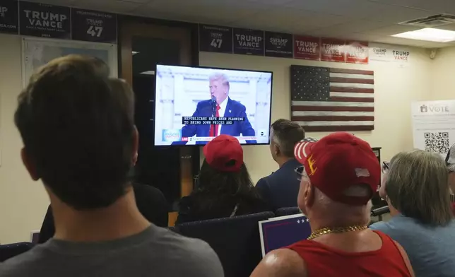 Supporters of Republican presidential candidate former President Donald Trump watch his speech at the Republican National Convention in Milwaukee on a television at the Arizona GOP headquarters Thursday, July 18, 2024, in Phoenix. (AP Photo/Ross D. Franklin)