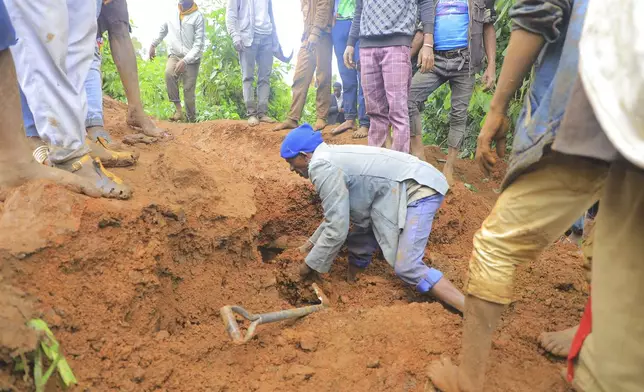 In this handout photo released by Gofa Zone Government Communication Affairs Department, a man searches for survivors hundreds of people gather at the site of a mudslide in the Kencho Shacha Gozdi district, Gofa Zone, southern Ethiopia, Monday, July 22, 2024. At least 146 people were killed in mudslides in a remote part of Ethiopia that has been hit with heavy rainfall, according to local authorities. (Gofa Zone Government Communication Affairs Department via AP)