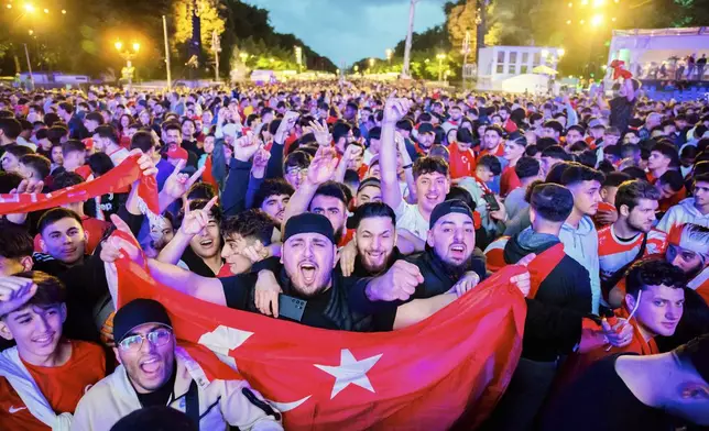 Turkey's fans cheer in the fan zone at the Brandenburg Gate in Berlin, Germany, July 2, 2024 during the screening of a round of sixteen match between Austria and Turkey at the Euro 2024 soccer tournament in Leipzig, Germany. (Christoph Soeder/dpa via AP)