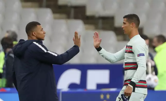 FILE - In this Sunday, Oct. 11, 2020 file photo France's Kylian Mbappe and Portugal's Cristiano Ronaldo, right, greet each other before the Nations League soccer match between France and Portugal at the Stade de France in Saint-Denis, north of Paris, France. Cristiano Ronaldo vs. Kylian Mbappe is not just a clash of soccer icons but a clash of generations. They’ll go head to head when Portugal plays France in the Euro 2024 quarterfinals on Friday and their heavyweight meeting just got a little bit bigger after Ronaldo said this would be his last European Championship. (AP Photo/Thibault Camus, File)