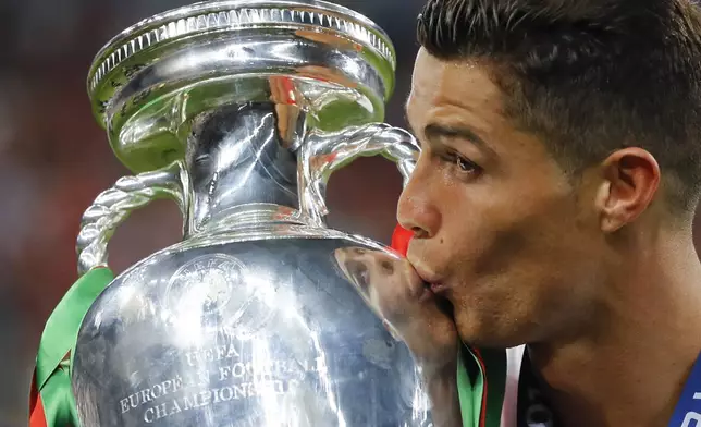 FILE - Portugal's Cristiano Ronaldo kisses the trophy at the end of the Euro 2016 final soccer match between Portugal and France at the Stade de France in Saint-Denis, north of Paris, Sunday, July 10, 2016. Cristiano Ronaldo vs. Kylian Mbappe is not just a clash of soccer icons but a clash of generations. They’ll go head to head when Portugal plays France in the Euro 2024 quarterfinals on Friday and their heavyweight meeting just got a little bit bigger after Ronaldo said this would be his last European Championship. (AP Photo/Frank Augstein, File)