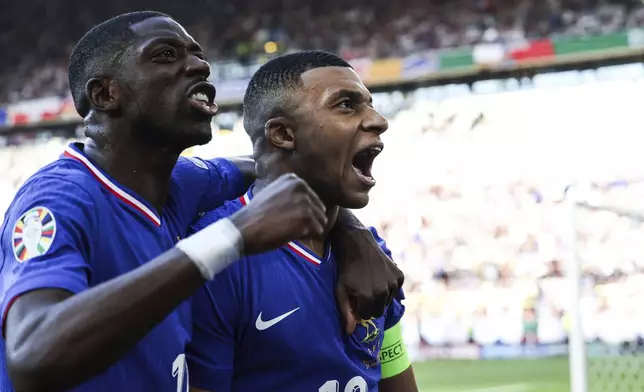FILE -Kylian Mbappe of France, right, celebrates after scoring a penalty kick during a Group D match between the France and Poland at the Euro 2024 soccer tournament in Dortmund, Germany, Tuesday, June 25, 2024. Cristiano Ronaldo vs. Kylian Mbappe is not just a clash of soccer icons but a clash of generations. They’ll go head to head when Portugal plays France in the Euro 2024 quarterfinals on Friday and their heavyweight meeting just got a little bit bigger after Ronaldo said this would be his last European Championship.(Friso Gentsch/dpa via AP, File)