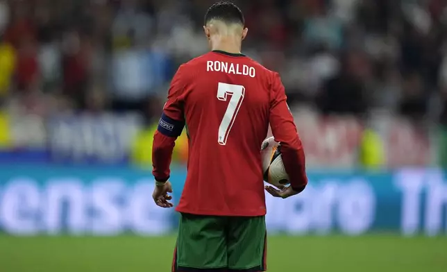 FILE - Portugal's Cristiano Ronaldo prepares to kick a penalty during a round of sixteen match between Portugal and Slovenia at the Euro 2024 soccer tournament in Frankfurt, Germany, Monday, July 1, 2024. Cristiano Ronaldo vs. Kylian Mbappe is not just a clash of soccer icons but a clash of generations. They’ll go head to head when Portugal plays France in the Euro 2024 quarterfinals on Friday and their heavyweight meeting just got a little bit bigger after Ronaldo said this would be his last European Championship. (AP Photo/Matthias Schrader, File)