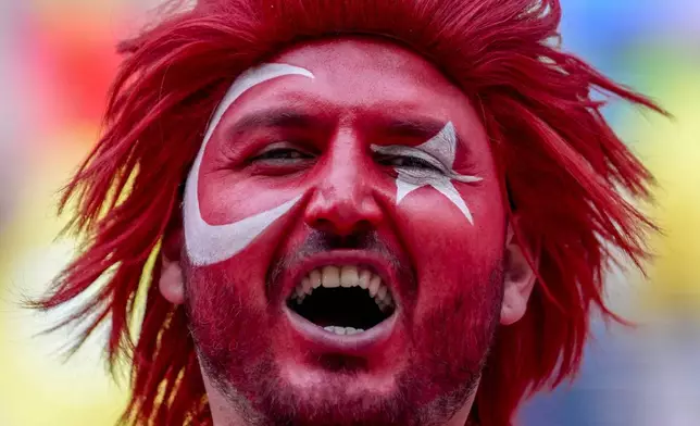 A Turkish fan celebrates prior to a round of sixteen match between Austria and Turkey at the Euro 2024 soccer tournament in Leipzig, Germany, Tuesday, July 2, 2024. (AP Photo/Darko Vojinovic)