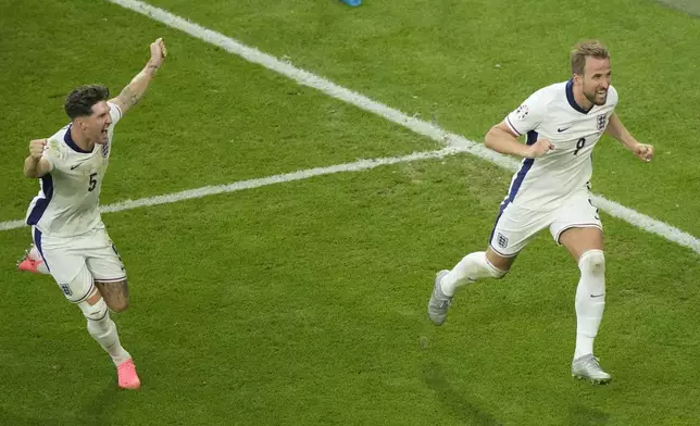 England's Harry Kane, right, celebrates with John Stones after scoring his side's second goal during a round of sixteen match between England and Slovakia at the Euro 2024 soccer tournament in Gelsenkirchen, Germany, Sunday, June 30, 2024. (AP Photo/Ebrahim Noroozi)