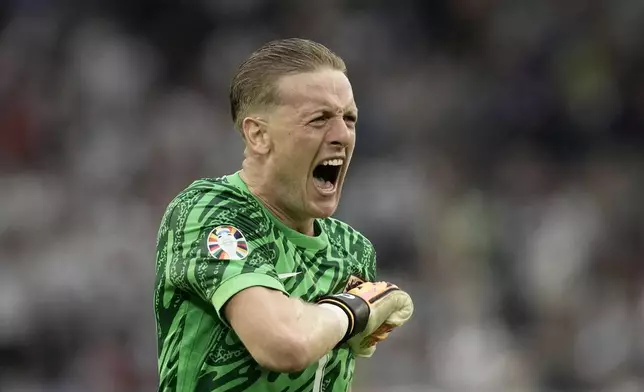 England's goalkeeper Jordan Pickford reacts after Jude Bellingham scored their first goal during a round of sixteen match between England and Slovakia at the Euro 2024 soccer tournament in Gelsenkirchen, Germany, Sunday, June 30, 2024. (AP Photo/Thanassis Stavrakis)
