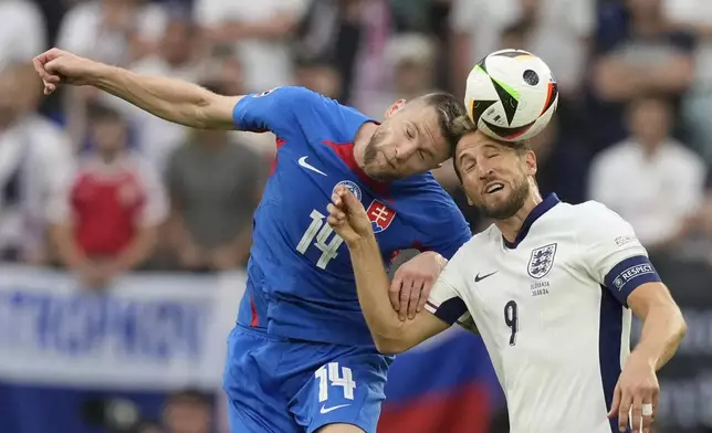 England's Harry Kane, right, jumps for the ball with Slovakia's Milan Skriniar during a round of sixteen match between England and Slovakia at the Euro 2024 soccer tournament in Gelsenkirchen, Germany, Sunday, June 30, 2024. (AP Photo/Antonio Calanni)
