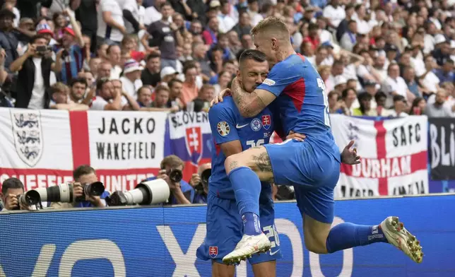 Slovakia's Ivan Schranz, left, celebrates with Slovakia's Juraj Kucka after scoring his side's opening goal during a round of sixteen match between England and Slovakia at the Euro 2024 soccer tournament in Gelsenkirchen, Germany, Sunday, June 30, 2024. (AP Photo/Ariel Schalit)