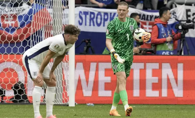 England's goalkeeper Jordan Pickford and John Stones, left, react after Slovakia's Ivan Schranz scored the opening goal during a round of sixteen match between England and Slovakia at the Euro 2024 soccer tournament in Gelsenkirchen, Germany, Sunday, June 30, 2024. (AP Photo/Thanassis Stavrakis)