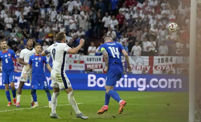 England's Harry Kane, center left, scores his side's second goal during a round of sixteen match between England and Slovakia at the Euro 2024 soccer tournament in Gelsenkirchen, Germany, Sunday, June 30, 2024. (AP Photo/Thanassis Stavrakis)