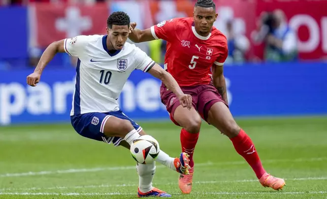 England's Jude Bellingham, left, and Switzerland's Manuel Akanji challenge for the ball during a quarterfinal match between England and Switzerland at the Euro 2024 soccer tournament in Duesseldorf, Germany, Saturday, July 6, 2024. (AP Photo/Darko Vojinovic)