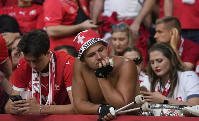 Switzerland supporters react after their team lost in the quarterfinal match against England at the Euro 2024 soccer tournament in Duesseldorf, Germany, Saturday, July 6, 2024. (AP Photo/Thanassis Stavrakis)