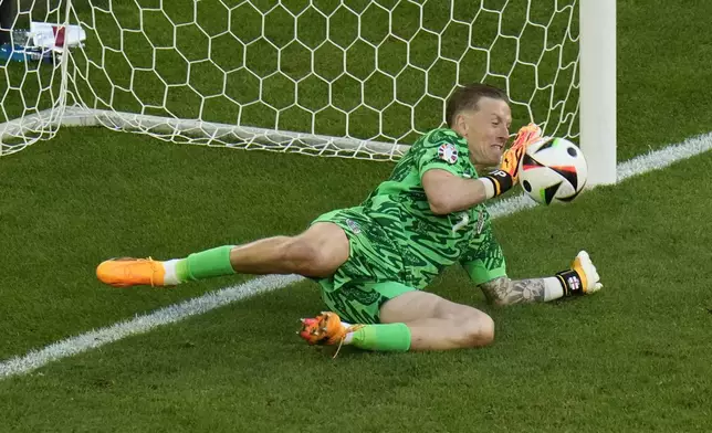 England's goalkeeper Jordan Pickford makes a save during a penalty shootout during a quarter final match between England and Switzerland at the Euro 2024 soccer tournament in Duesseldorf, Germany, Saturday, July 6, 2024. (AP Photo/Hassan Ammar)