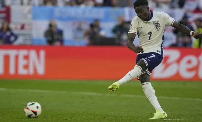 England's Bukayo Saka scores during the penalty shootout of a quarterfinal match between England and Switzerland at the Euro 2024 soccer tournament in Duesseldorf, Germany, Saturday, July 6, 2024. (AP Photo/Martin Meissner)