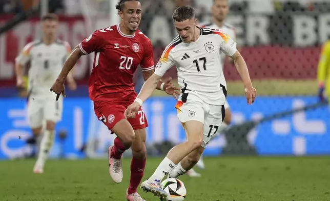 Germany's Florian Wirtz, right, and Denmark's Yussuf Poulsen fight for the ball during a round of sixteen match at the Euro 2024 soccer tournament in Dortmund, Germany, Saturday, June 29, 2024. (AP Photo/Darko Vojinovic)