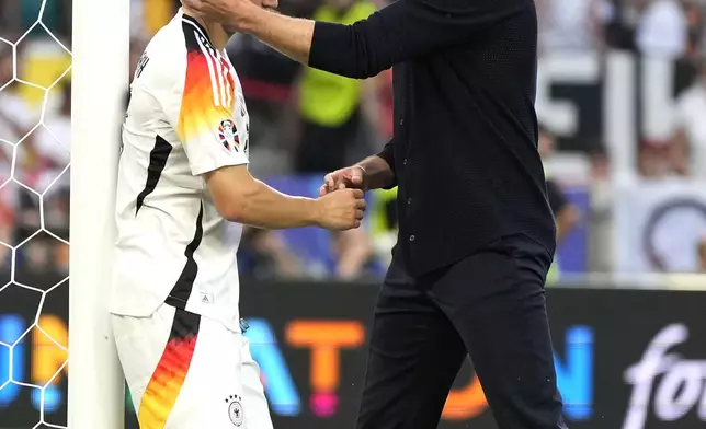 Germany's Joshua Kimmich, left, is hugged by Germany's head coach Julian Nagelsmann at the end of a quarter final match between Germany and Spain at the Euro 2024 soccer tournament in Stuttgart, Germany, Friday, July 5, 2024. (AP Photo/Matthias Schrader)