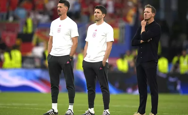 Germany's head coach Julian Nagelsmann, right, stands on there pitch at the end of a quarter final match between Germany and Spain at the Euro 2024 soccer tournament in Stuttgart, Germany, Friday, July 5, 2024. (AP Photo/Matthias Schrader)